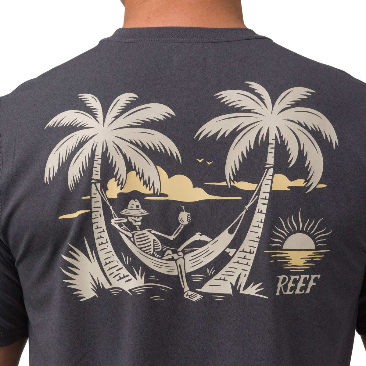 Back view close-up of Siesta Performance Shirt showing hammock skeleton graphic between palm trees on charcoal fabric.