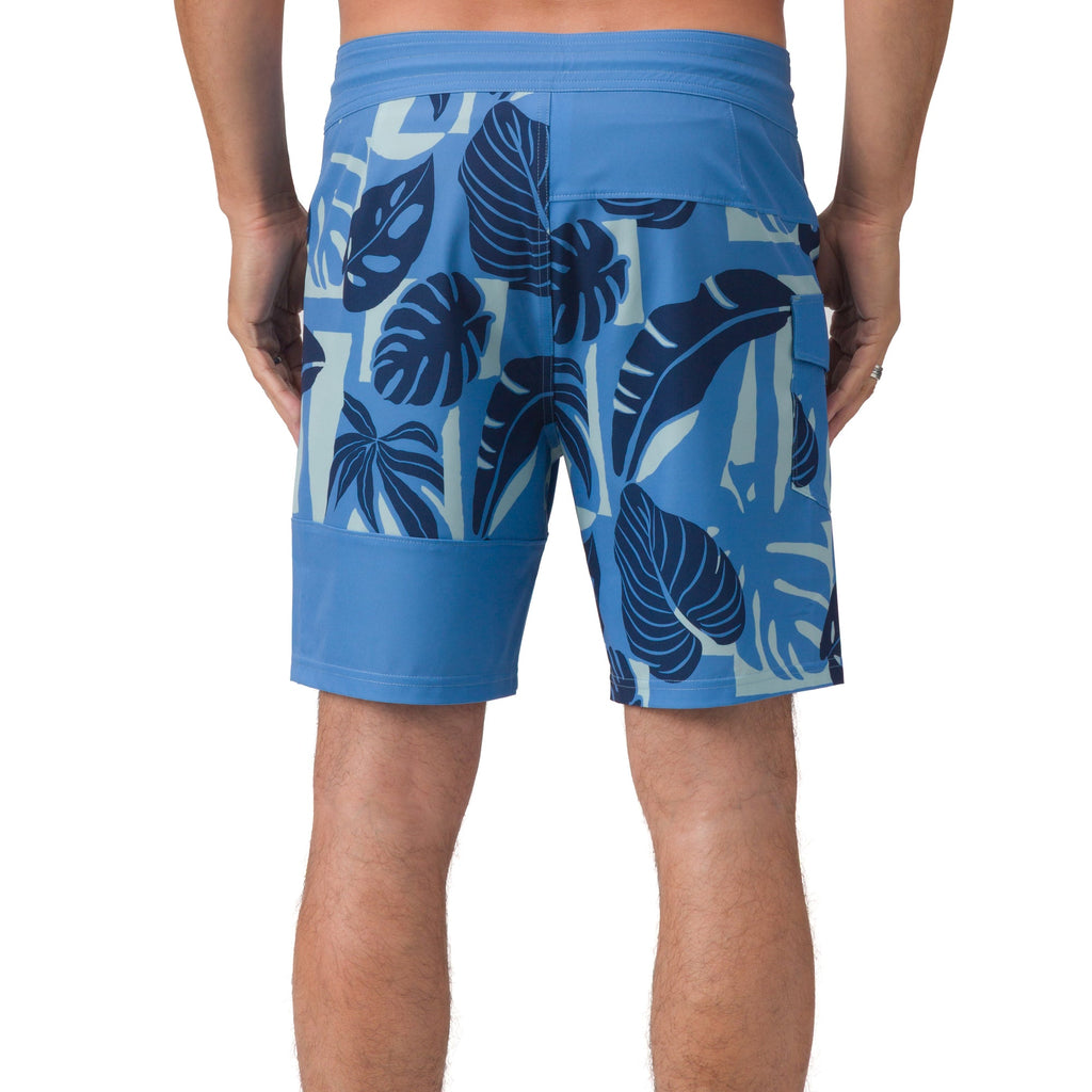 Back view of men’s Gonzo Boardshort in blue with tropical leaf print, designed for beach comfort and active lifestyle.