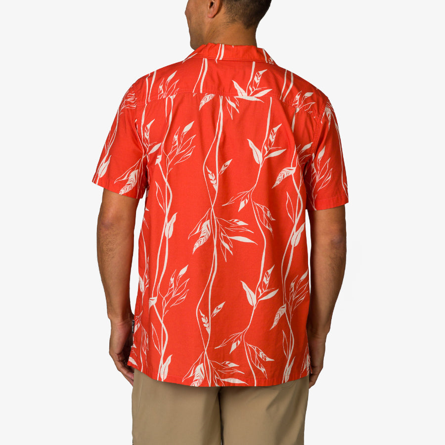 Back view of the Kaden Camp Shirt on a man, featuring red fabric with white leaf patterns, beach-inspired comfort design.