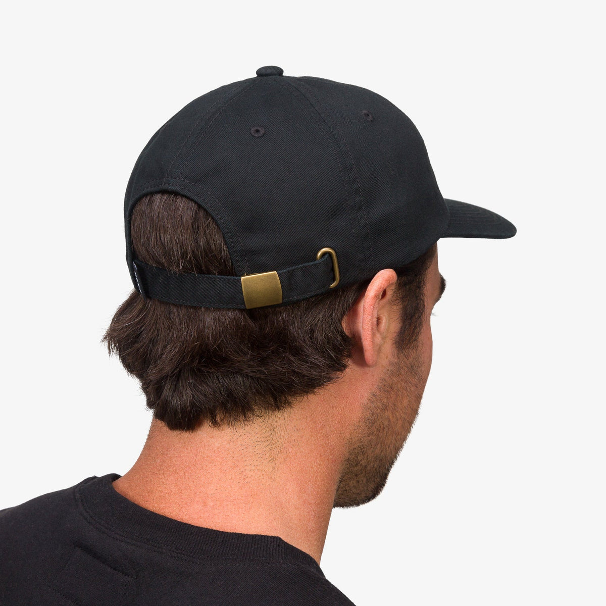 Back view of adult man wearing black Schotts Twill Hat with adjustable strap, surf-inspired comfort and durability
