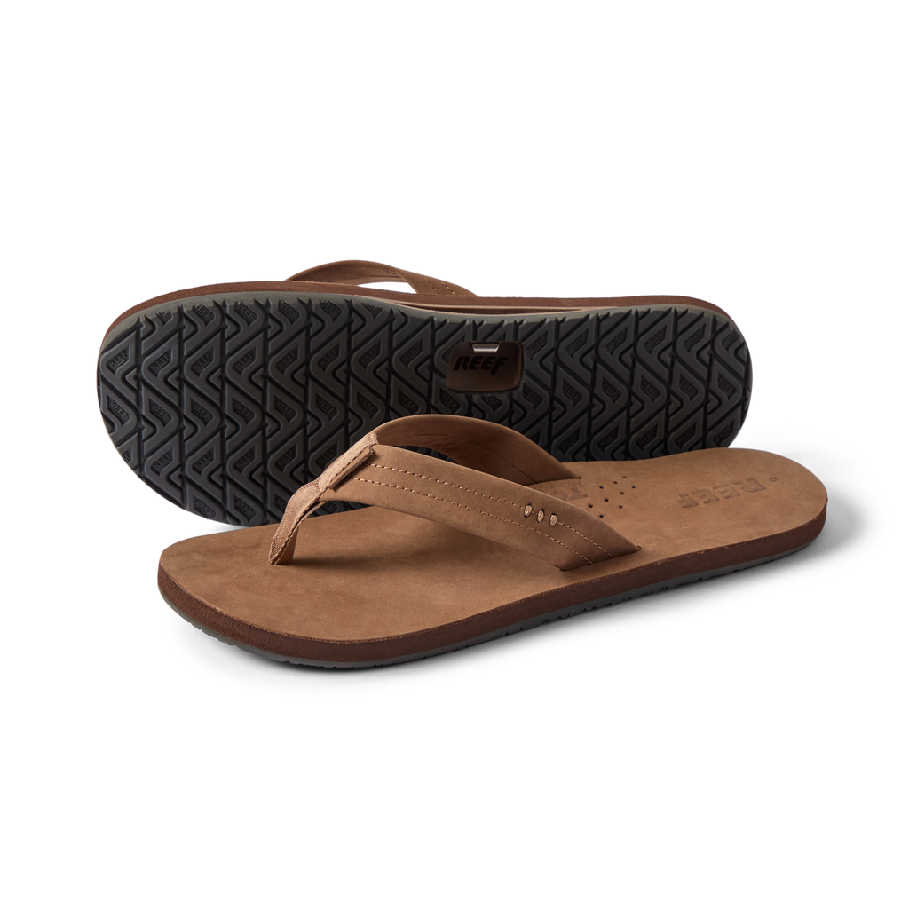 Reef Draftsmen men's brown sandals facing left with sole tread visible, featuring cushioned arch support and water-friendly design