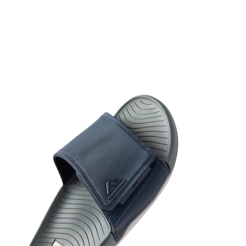 Close-up of the front and top of the right Phantom Slab slide in navy and grey, showing cushioned footbed and adjustable strap.