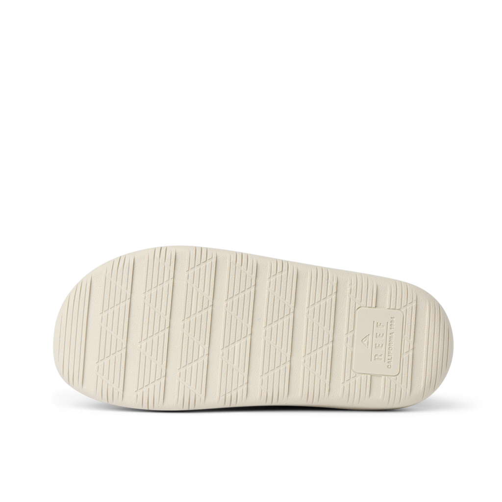 Rambler Kicker sandal sole facing up in off-white with textured grip and REEF branding for durable, lightweight comfort