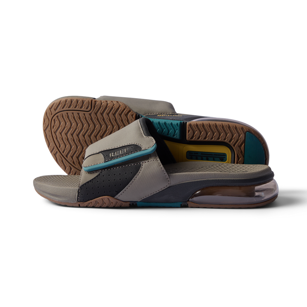 Close-up of tan and spruce slides facing right showing cushioned footbed, textured sole, and anatomical arch support design