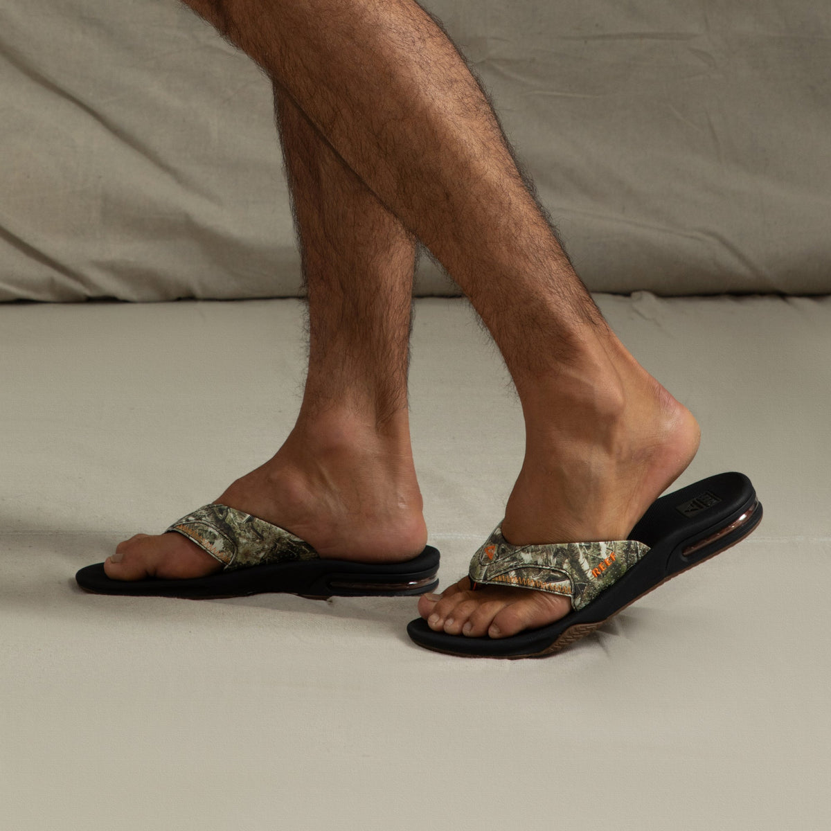 Fanning men's sandals facing right, showing side view with camo straps, soft cushioning, and anatomical arch support.