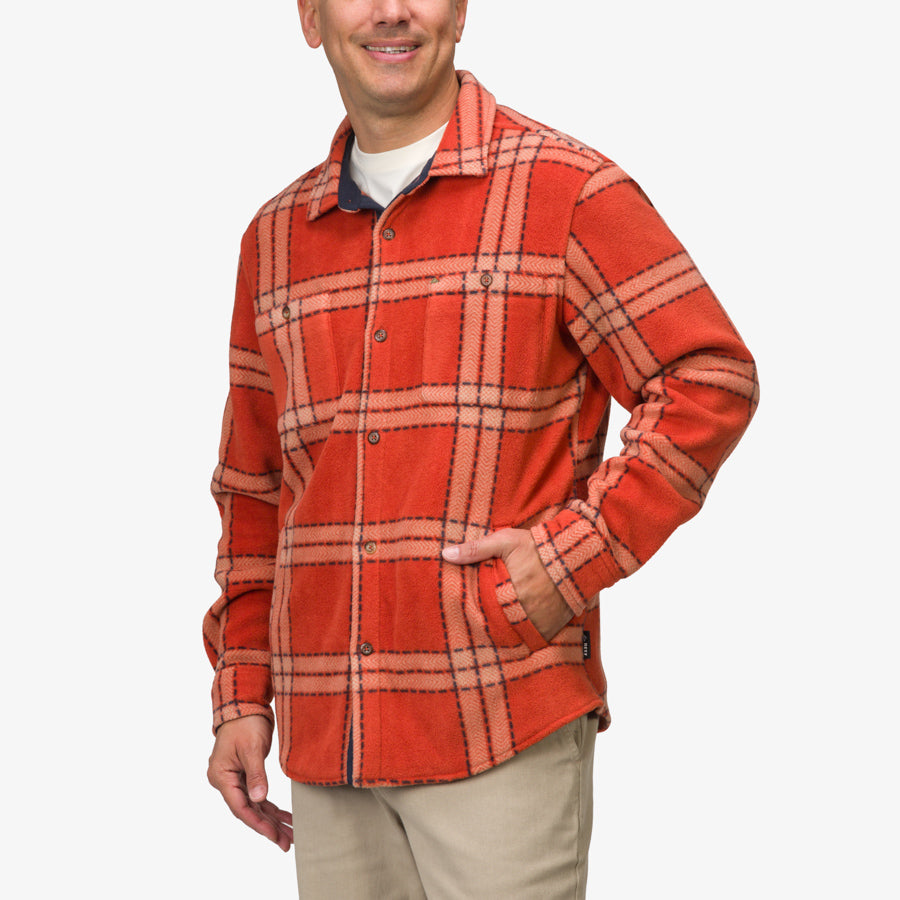 Man wearing a front-facing Karter Shirt Jacket in cinnabar plaid with button closure and side pocket, surf-inspired comfort.