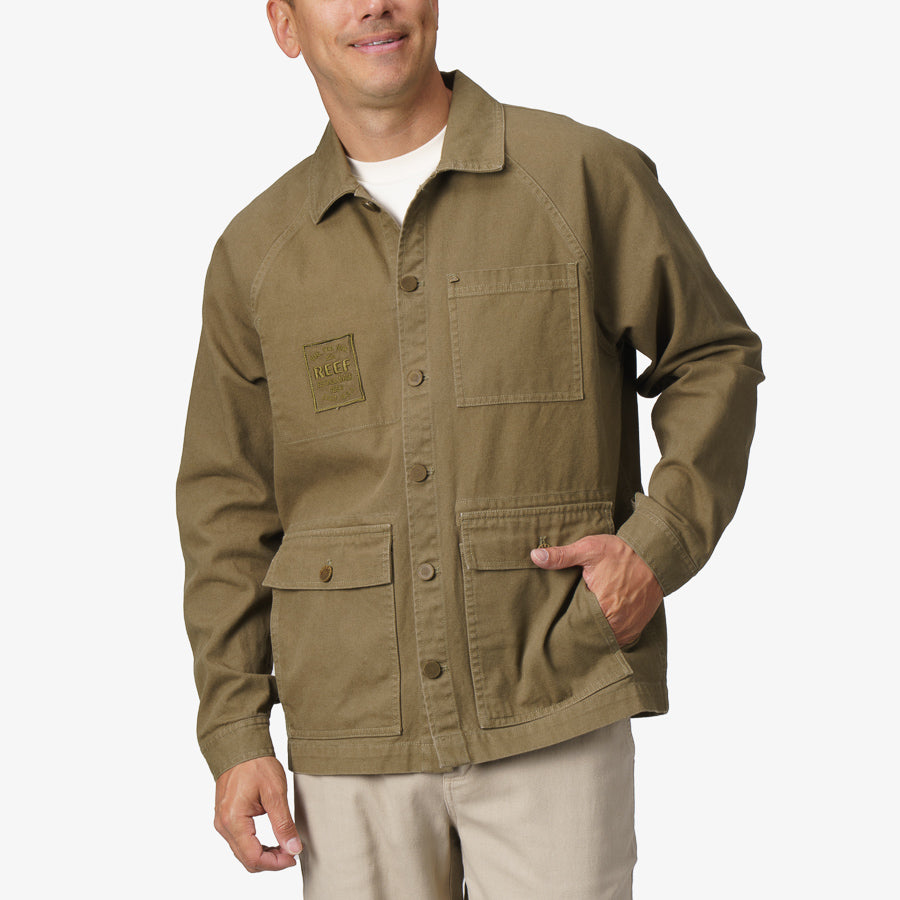 Front view of olive Landon Coat worn by a man, showcasing durable fabric, multiple pockets, and casual beach-inspired style.