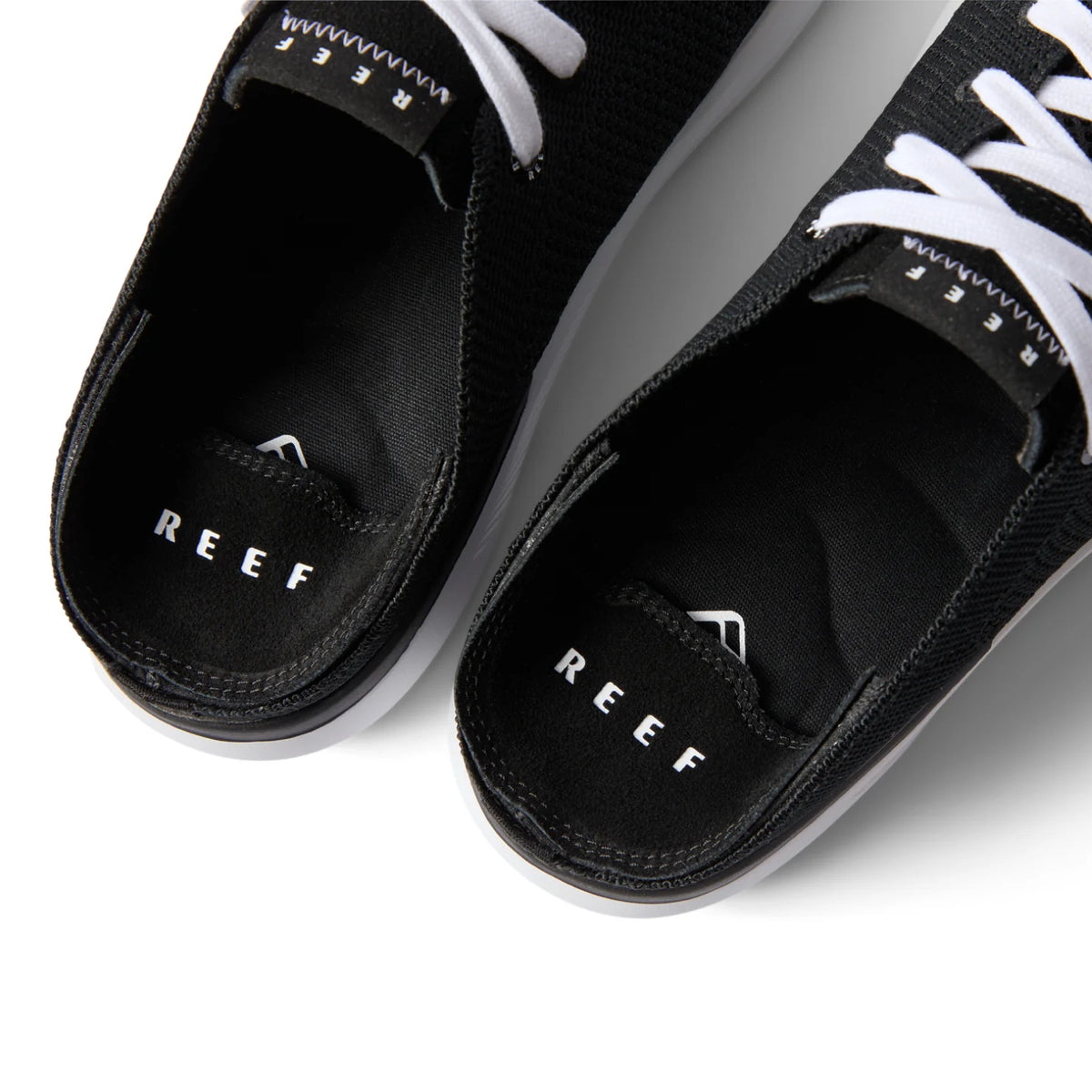 Close-up top view of the black Neptune HT shoes facing upward, showcasing REEF comfort and arch support.
