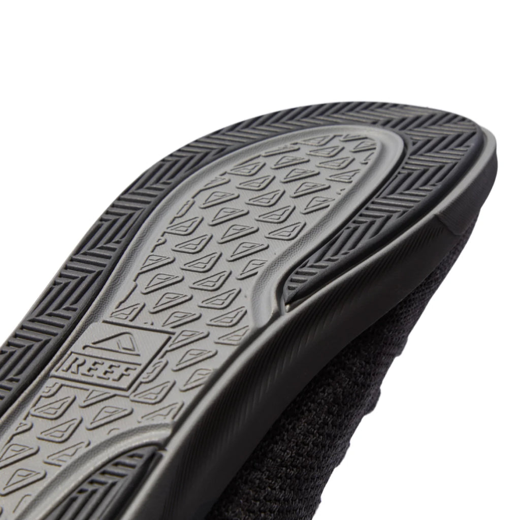 Close-up of the Neptune HT sole facing up showing durable textured tread and REEF logo with extra cushioning and arch support features.
