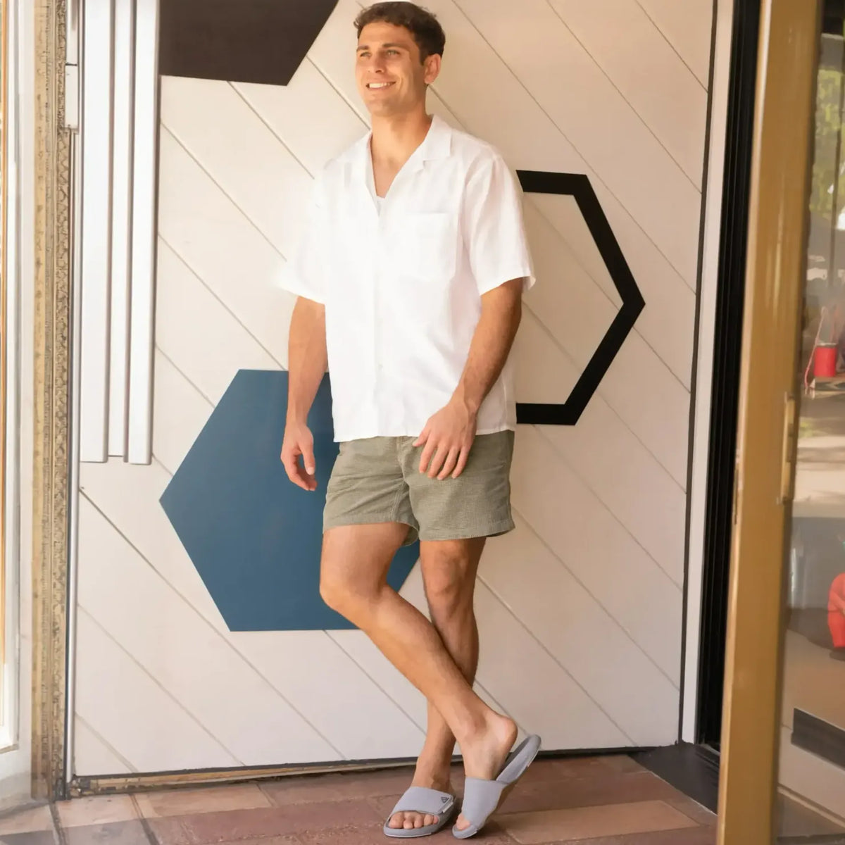 Man wearing Phantom Slab grey slides facing forward, showing comfortable, beach-inspired footwear with anatomical arch support.