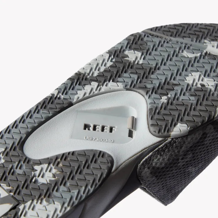 Close-up of underside of Fanning Slide facing down, showing water-friendly camo sole with built-in bottle opener.
