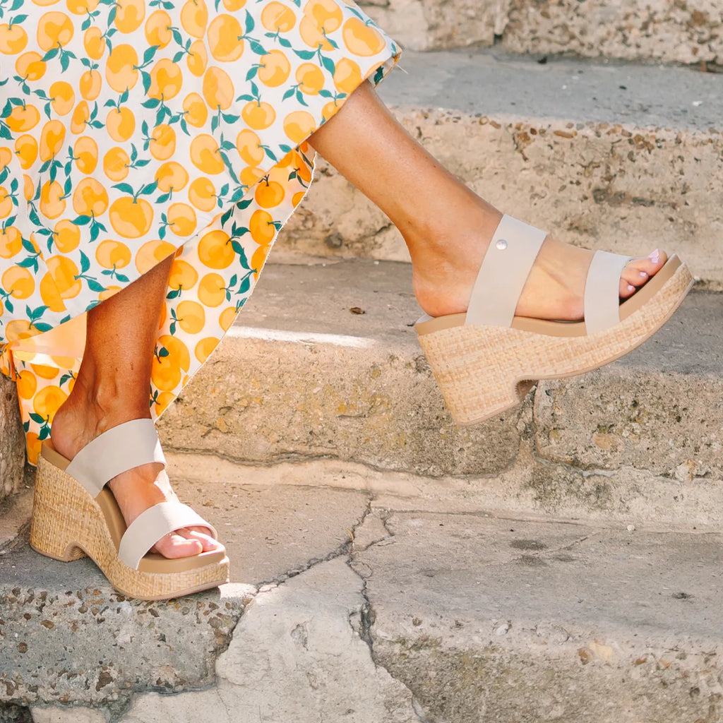 Sunset Ibiza x Jenny sandals facing right on stone steps, featuring woven platform and water-friendly cushioned footbed