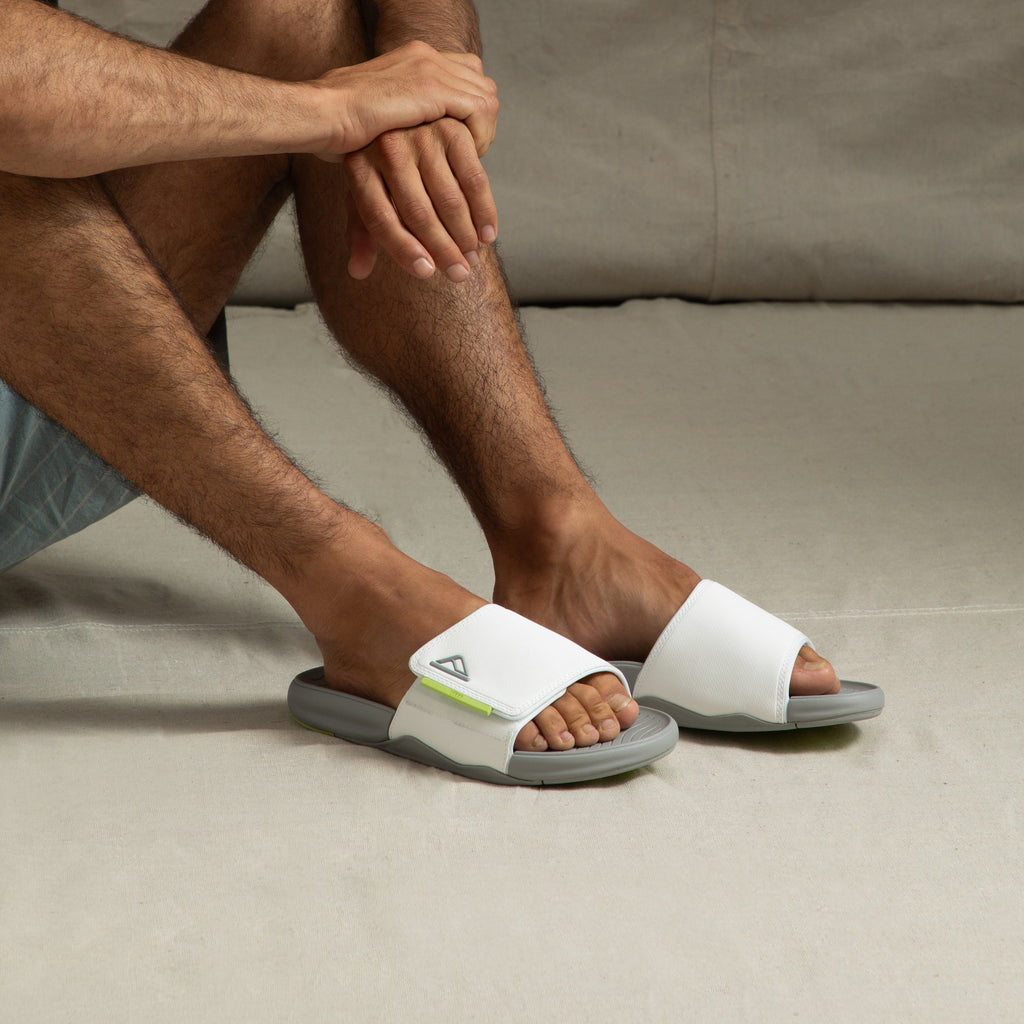 Man wearing Phantom Slab slides facing forward, showing soft white straps and cushioned arch support design.
