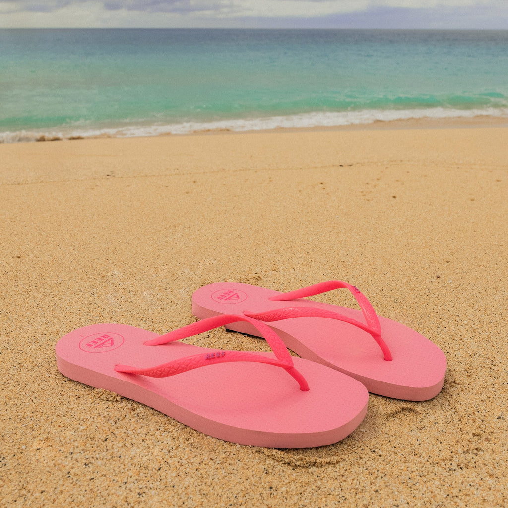 Seaside Square Toe pink sandals facing right on sandy beach with ocean background, designed for comfort and durability.